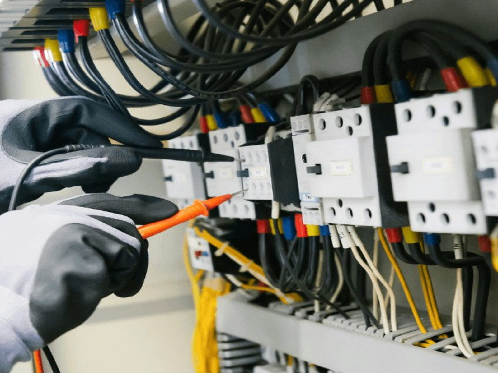 Electrician testing the wiring in a switchboard